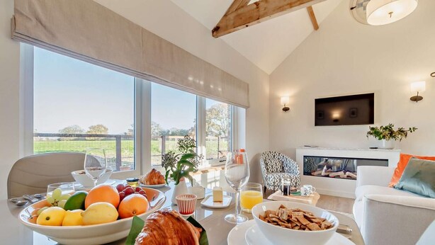 A dining area with a table set for breakfast, including fruits, pastries, and beverages, with a view of the outdoors. - 1 Bed in Market Weston (oc-t27890) (Market Weston)