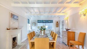 A dining area with a checkered table, yellow chairs, a fireplace, and a view of the room. - 4 Bed in West Bexington (oc-s28233) (West Bexington)