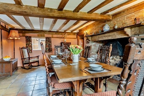 A traditional dining room with a wooden table set for six, surrounded by ornate chairs. A fireplace with a brick wall and a wooden mantel is visible in the background. - 3 Bed in Rumburgh (oc-c27094) (Rumburgh)
