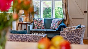 A cozy living room with a sofa, patterned armchairs, and a chessboard. - 3 Bed in Marden (oc-w28286) (Horsmonden)