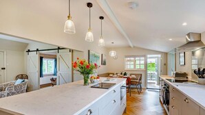 A spacious kitchen with a large island, pendant lighting, and a view to the outdoors. - 3 Bed in Marden (oc-w28286) (Horsmonden)