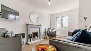 A modern living room with a fireplace, a flat-screen TV, and a comfortable seating area. - 2 Bed in Charlestown (oc-91449) (Charlestown)