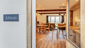 A dining area with wooden furniture, a sign reading "Abbots," and a view of the outdoors through large windows. - 2 Bed in Outwell (oc-a28259) (Upwell)