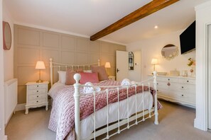 A bedroom with a white four-poster bed, bedside tables, a dresser, and a mirror. - 4 Bed in East Rudham (oc-t28312) (East Rudham)
