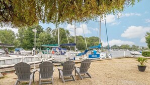 A marina with boats docked, a covered area, and outdoor seating.