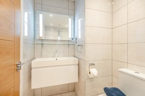 A bathroom with a white sink, mirror, and toilet. - 2 Bed in Christchurch (oc-r27892) (Christchurch)