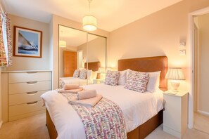 A well-lit bedroom with a large bed, bedside tables, a mirror, and a dresser. - 3 Bed in Christchurch (oc-r27894) (Christchurch)