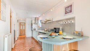 A kitchen with a breakfast bar, a radio, and a heart-shaped artwork on the wall. - 2 Bed in Barnby (oc-t28265) (North Cove)