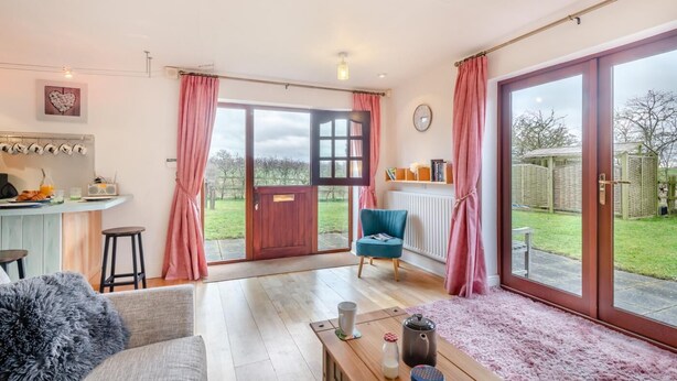A spacious living area with a kitchen, a dining area, and a large sliding glass door leading to a garden. - 2 Bed in Barnby (oc-t28265) (North Cove)