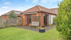 A brick house with a tiled roof, a wooden fence, a bench, and a small garden. - 2 Bed in Barnby (oc-t28265) (North Cove)