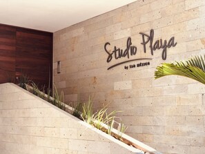 A modern interior with a sign reading "Studio Playa by Taó México" on a speckled wall. - Stylish Studios with Rooftop Pool (Playa del Carmen)
