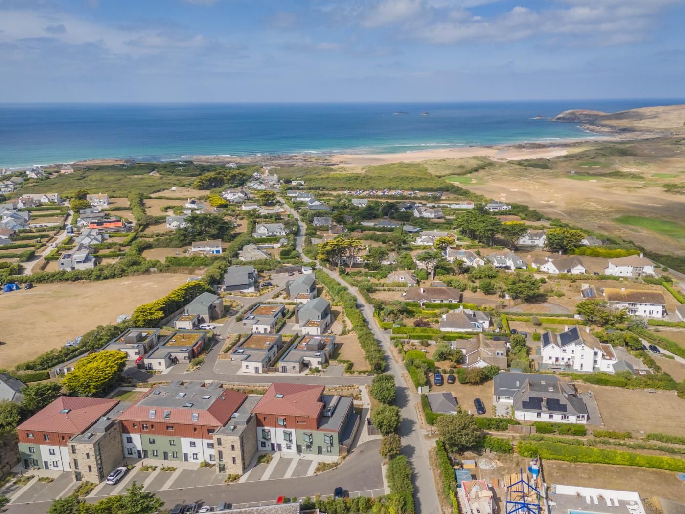 Un quartier résidentiel avec des maisons, des rues et une plage en arrière-plan.