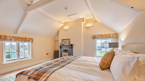 A bedroom with a large bed, a fireplace, and two windows with curtains. - 2 Bed in Southgate (oc-p28298) (Southgate)