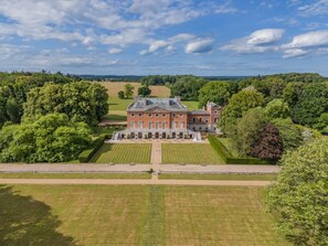A large, historic building with a symmetrical facade, surrounded by well-manicured lawns and trees. - 7 Bed in Wolterton (oc-t28256) (Wolterton)