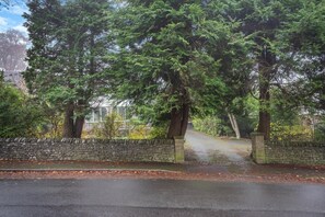 Un mur de pierre avec un chemin pavé menant à un bâtiment.