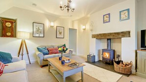 A cozy living room with a sofa, coffee table, and fireplace. - 2 Bed in Maentwrog (oc-g28262) (Maentwrog)