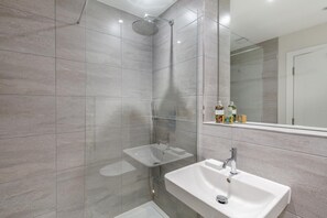 A modern bathroom with a walk-in shower, a sink, and a mirror. - 2 Bed in Harlyn Bay (oc-a28321) (Harlyn Bay)