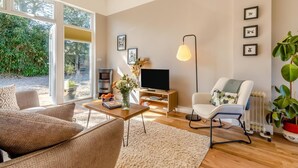 Ein modernes Wohnzimmer mit Sofa, Couchtisch, Fernseher und Kamin.