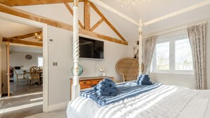 A bedroom with a four-poster bed, a television on the wall, and a view of the outside through a window. - 2 Bed in Chalbury (oc-t28279) (Horton)