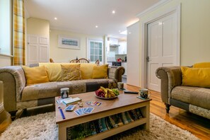 Ein Wohnzimmer mit einer Couch, einem Couchtisch und einem Bücherregal.