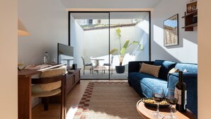 Un salon moderne comprenant un canapé, une table basse, un téléviseur et un coin repas avec des chaises et une table.