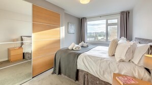A modern bedroom with a large bed, a bedside table, a wardrobe, and a window with curtains. - 2 Bed in Amble (oc-b28345) (Amble)