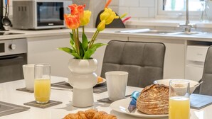 Uma mesa com um croissant, um pão e um copo de sumo de laranja para o pequeno-almoço.