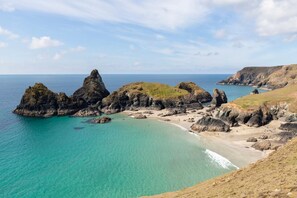 A coastal landscape with rocky formations, clear turquoise waters, and a sandy beach. - 3 Bed in Ruan Minor (oc-t28367) (Ruan Minor)