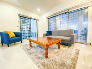 Ein Wohnzimmer mit einem blauen Sofa, einem grauen Sofa und einem Holztisch.