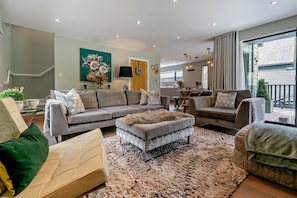 A modern living room with a sectional sofa, ottoman, and a shaggy rug.