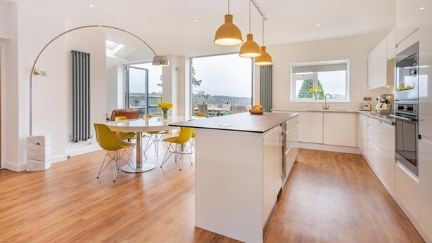 A modern kitchen with a central island, pendant lighting, and a view of the city. - 4 Bed in Killay (oc-c28372) (Killay)