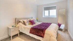 A bedroom with a bed, bedside table, nightstand, window, and a full-length mirror. - 4 Bed in Killay (oc-c28372) (Killay)