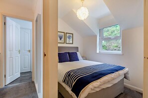 A bedroom with a bed, a window, and a door. - 3 Bed in Porthleven (oc-s28377) (Porthleven)
