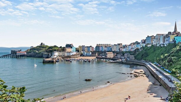 A coastal town with a sandy beach, a pier, and colorful buildings. - 2 Bed in Tenby (oc-f28369) (Tenby)