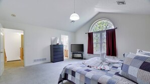 A bedroom with a bed, a dresser, a television, and a window with curtains. - Backyard lake-Boat– Kayaks • Firepit • Game room• pool access • Pet-friendly (Coolbaugh Township)