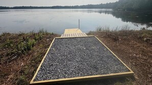 A wooden dock leading to a gravel platform by a calm lake. - Backyard lake-Boat– Kayaks • Firepit • Game room• pool access • Pet-friendly (Coolbaugh Township)