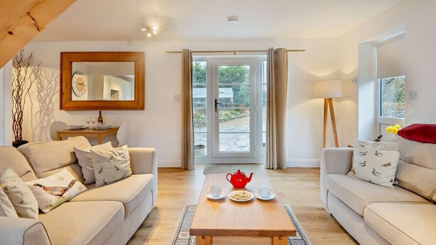 A cozy living room with two sofas, a wooden coffee table, and a large mirror. - 2 Bed in Bodham (oc-m15008) (Bodham)