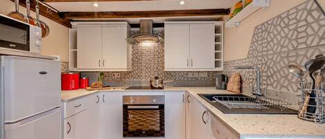 Een oven, een vaatwasser, kookgerei, borden en bestek