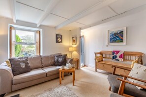 Ein gemütliches Wohnzimmer mit einer Couch, einer Holzbank und einem Couchtisch.