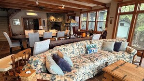A cozy living room with a large floral sofa, wooden coffee table, and a fireplace.