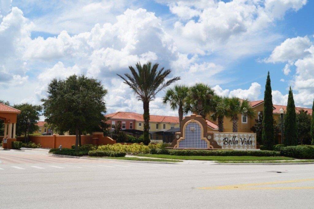 A residential area with a sign reading "Bella Vida" and a road in front.