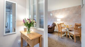 A room with a wooden desk, a vase of flowers, and a window with blinds. - 2 Bed in Holt (oc-r28378) (Holt)