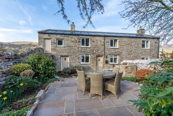 A stone house with a patio and outdoor seating.