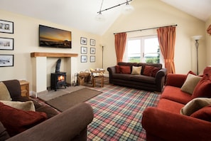 A cozy living room with a fireplace, a sofa, a couch, and a plaid rug. - 5 Bed in North Sunderland (oc-h28432) (North Sunderland)