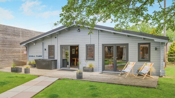 Een laag gebouw met terras, zitplaatsen buiten en een duidelijke ingang.
