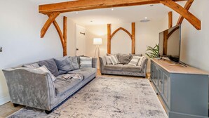 A living room with two sofas, a flat-screen TV, and a cabinet. - 4 Bed in Nottage (oc-t28401) (Nottage)