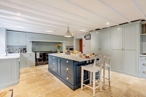 Eine moderne Küche mit einer zentralen Kochinsel, hellblauen Schränken und einer in Fischgrätenmuster angeordneten Fliesenrückwand.