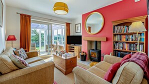A living room with a fireplace, sofa, television, and a bookshelf. - 2 Bed in Hudswell (oc-w28429) (Hudswell)