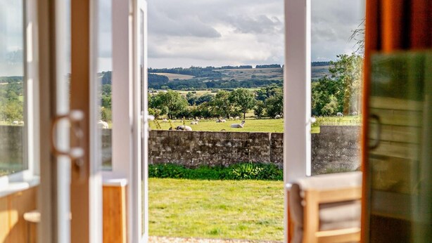 A view through a glass door of a countryside landscape with fields and trees. - 2 Bed in Hudswell (oc-w28429) (Hudswell)