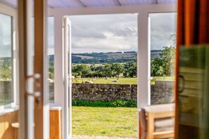 A view through a glass door of a countryside landscape with fields and trees. - 2 Bed in Hudswell (oc-w28429) (Hudswell)